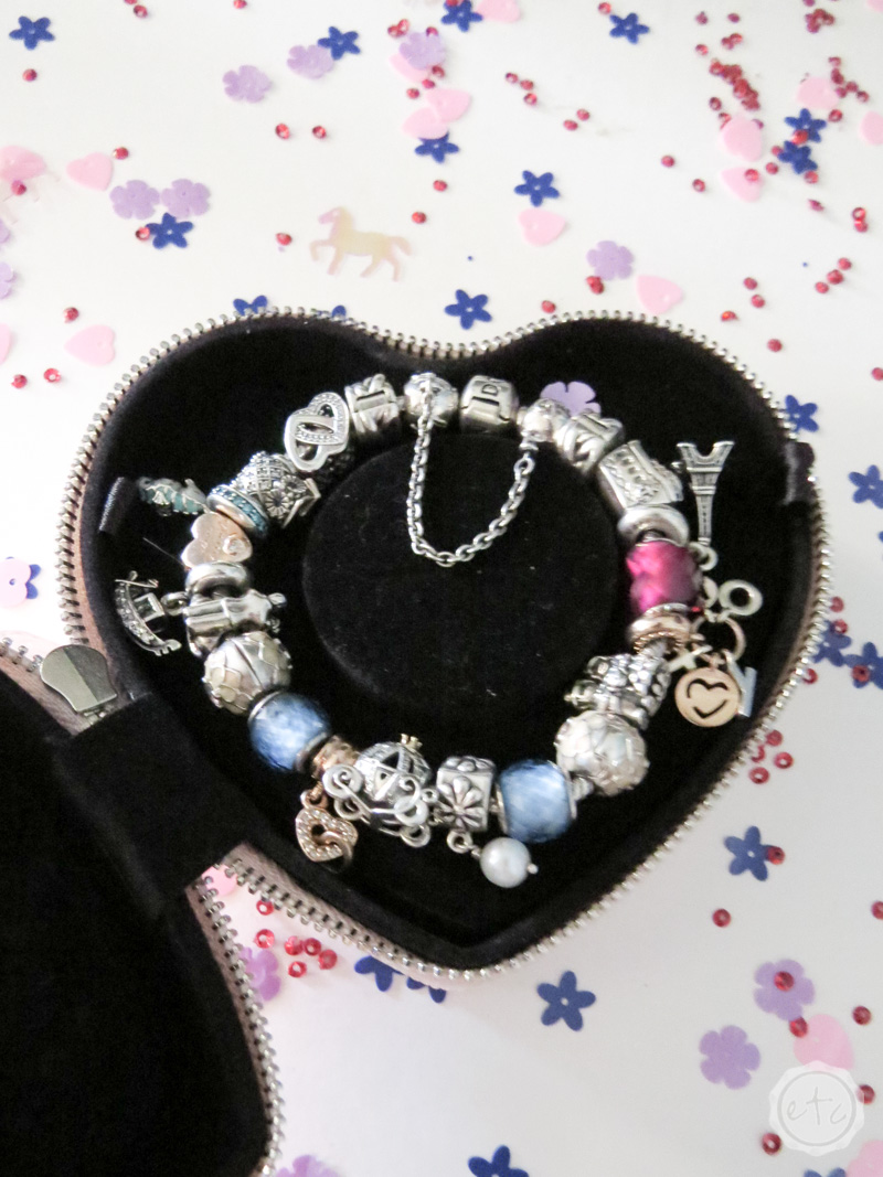 A pandora bracelet fully loaded with charms on a bed of anti-tarnish fabric inside it's case